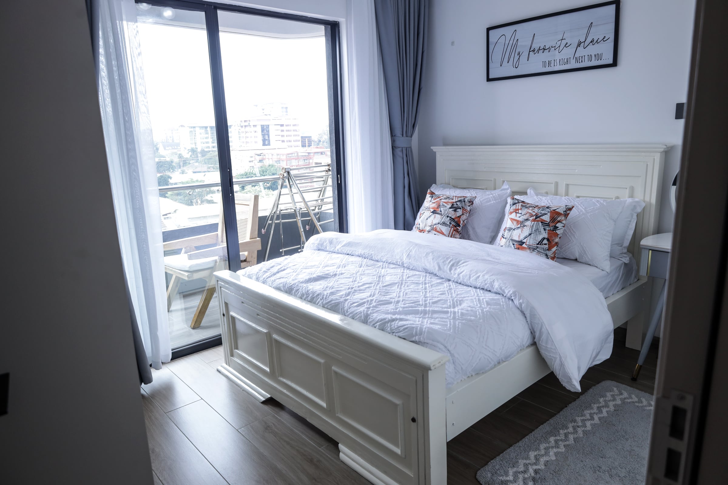 Bed beside a floor-to-ceiling window looking across the Kilimani skyline