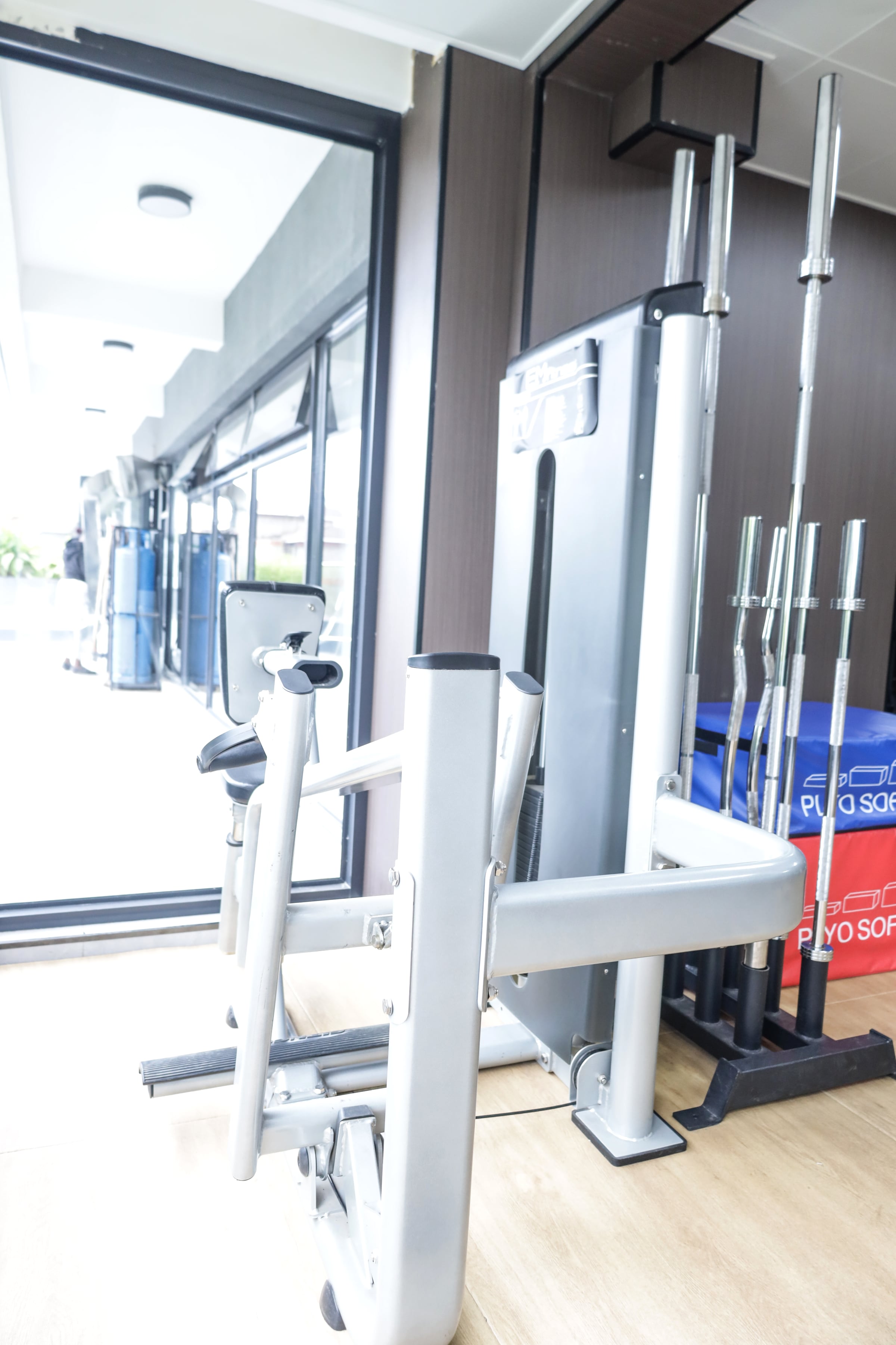 Free weights, dumbbell rack and benches in a mirrored gym