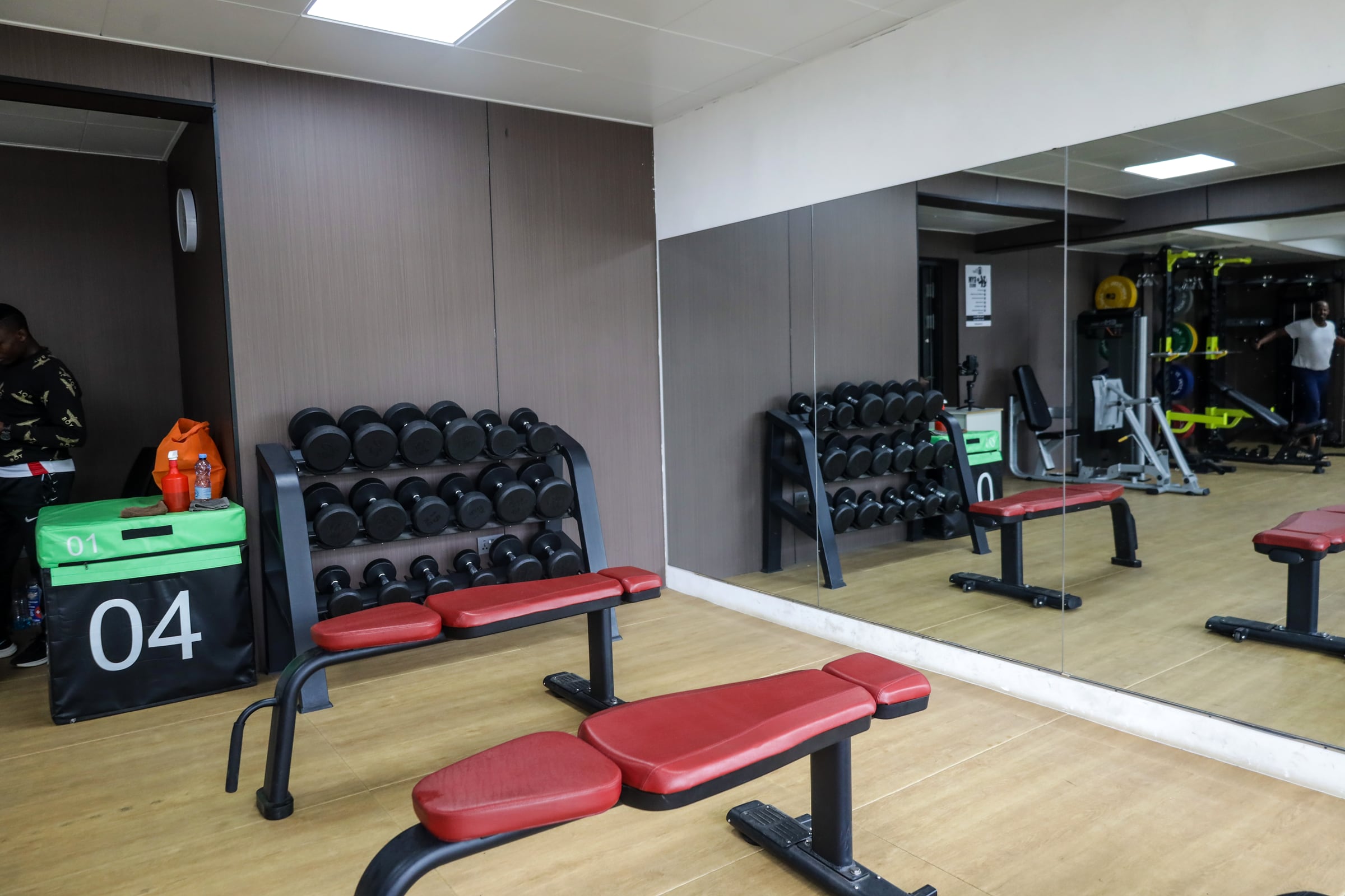 Residents gym with cardio machines and benches along a wall of windows